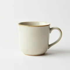 Taza de cerámica artesana con el borde dorado, fotografiada sobre fondo blanco