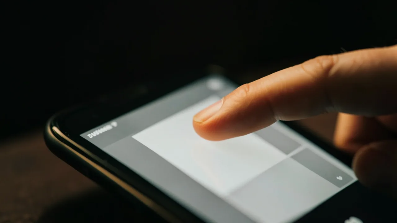 Dit tocant la pantalla d'un telèfon mòbil que mostra una interfície web